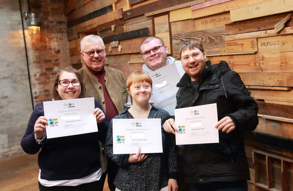 A group of trainees receive awards from Crumbs Charity Chairman