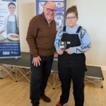 Simon Scarborough from the Marsham Court Hotel stands next to The CRUMBS Project Trainee of the Year, Emily at the charity's 2025 awards event