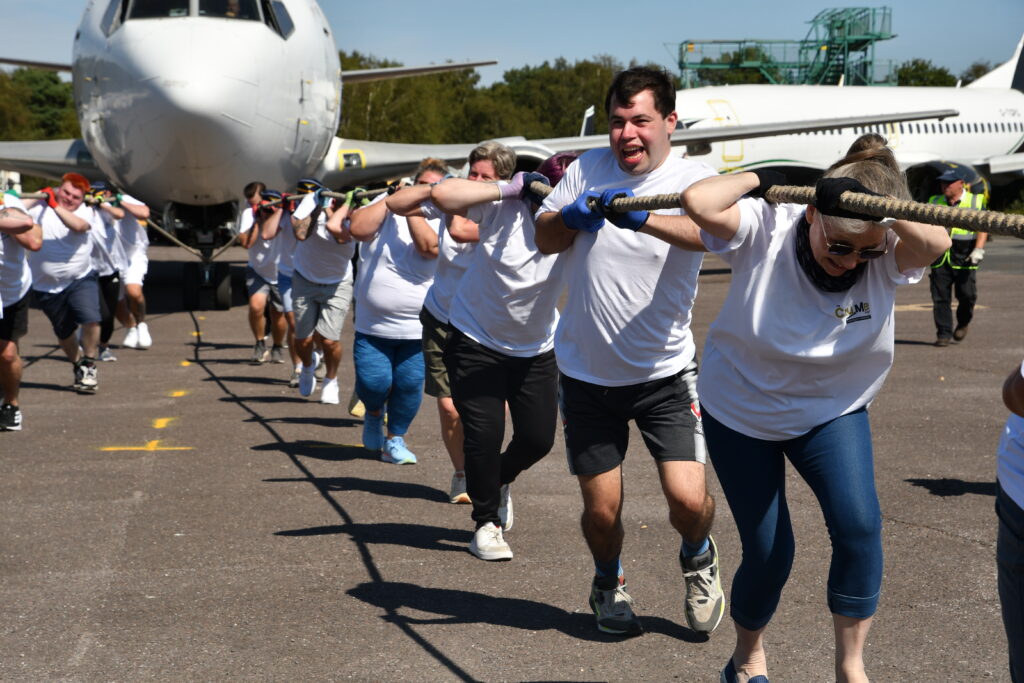 A team pull a rope attached to an aeroplane