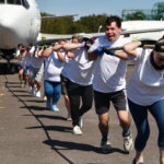 A team pull a rope attached to an aeroplane