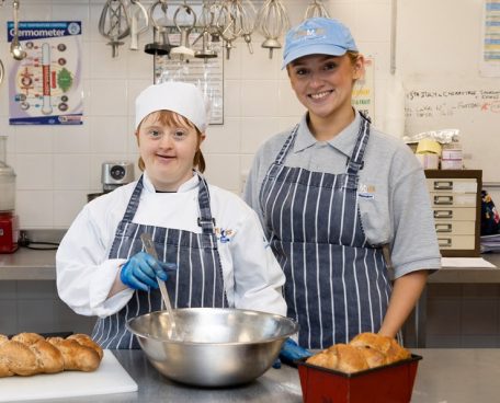 A trainee in the bakery with a volunteer