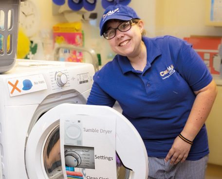 A trainee learning how to do laundry