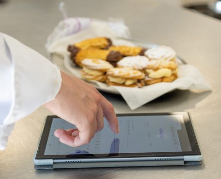 A trainee using a tablet computer in the training kitchen
