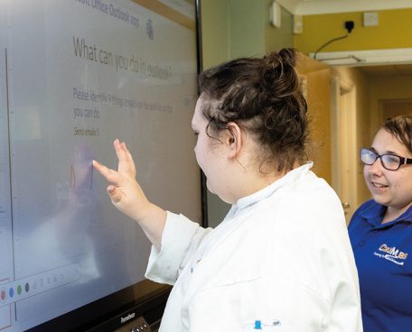 Two trainees using a digital smartboard